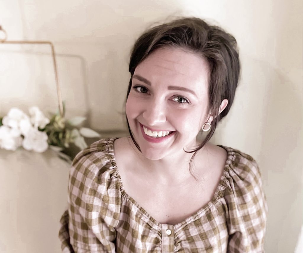 Woman with gingham shirt flower in background